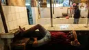 Seorang pria tidur di los pedagang daging yang kosong akibat aksi mogok pedagang di Pasar Kebayoran, Jakarta, Rabu (20/1/2021). Aksi mogok jualan para pedagang daging sapi sebagai bentuk protes kepada pemerintah atas tingginya harga daging sapi sejak akhir 2020. (Liputan6.com/Johan Tallo)