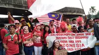Suporter Malaysia membentangkan bendera terbalik saat berfoto bersama dengan pendukung Indonesia jelang semifinal SEA Games di Stadion Shah Alam, Sabtu (26/8/2017). (Liputan6.com/Cakrayuri Nuralam)
