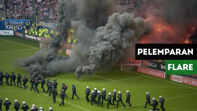 Fans Hamburg tak bisa menerima tim kesayangannya terdegradasi dan coba melemparkan flare ke lapangan.