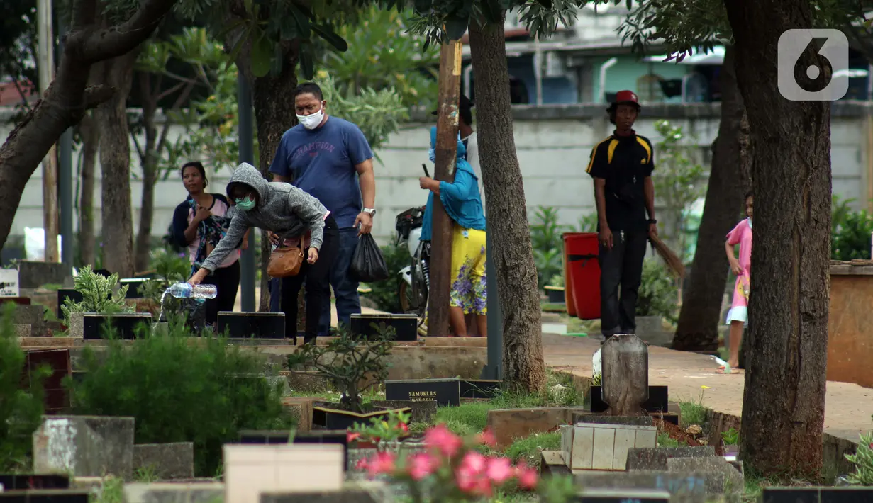 Peziarah menabur kembang di salah satu makam di Tempat Pemakaman Umum Karet Bivak, Jakarta, Sabtu (18/4/2020). Selama masa PSBB, peziarah yang memasuki kawasan TPU dibatasi dan diwajibkan menggunakan masker sebagai langkah pencegahan penyebaran virus Covid-19. (Liputan6.com/Helmi Fithriansyah)