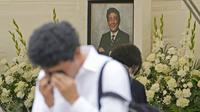 Reaksi seorang pria setelah memberi bunga dan doa untuk mantan Perdana Menteri Jepang Shinzo Abe di kuil Zojoji, Tokyo, Sabtu (8/7/2023). (AP Photo/Shuji Kajiyama)