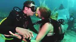 Sersan Thomas Mould dan Sandra Hyde berciuman usai melangsungkan pernikahan di Florida Keys National Marine Sanctuary (21/12). Setelah pacaran empat tahun pasangan ini memutuskan menikah di bawah laut. (Frazier Nivens/Florida Keys News Bureau via AP)