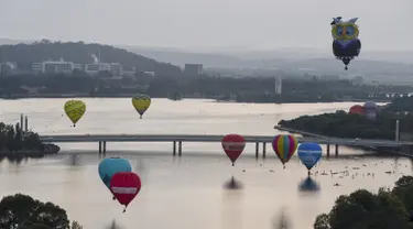 Sejumlah balon udara terbang bebas diatas danau Burley Griffin, Canberra,  Australia, (15/3). Ini dilakukan dilakukan dalam memperingati ulang tahun ke-30 festival Balloon Spectacular Canberra . (REUTERS / Lukas Coch)