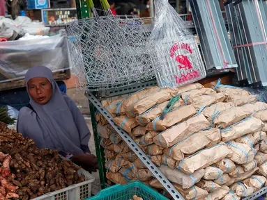 Seorang pedagang tusuk sate dan arang sedang menunggu pembeli di Pasar Kebayoran Lama, Jakarta, Rabu (28/6/2023). (Liputan6.com/Angga Yuniar)