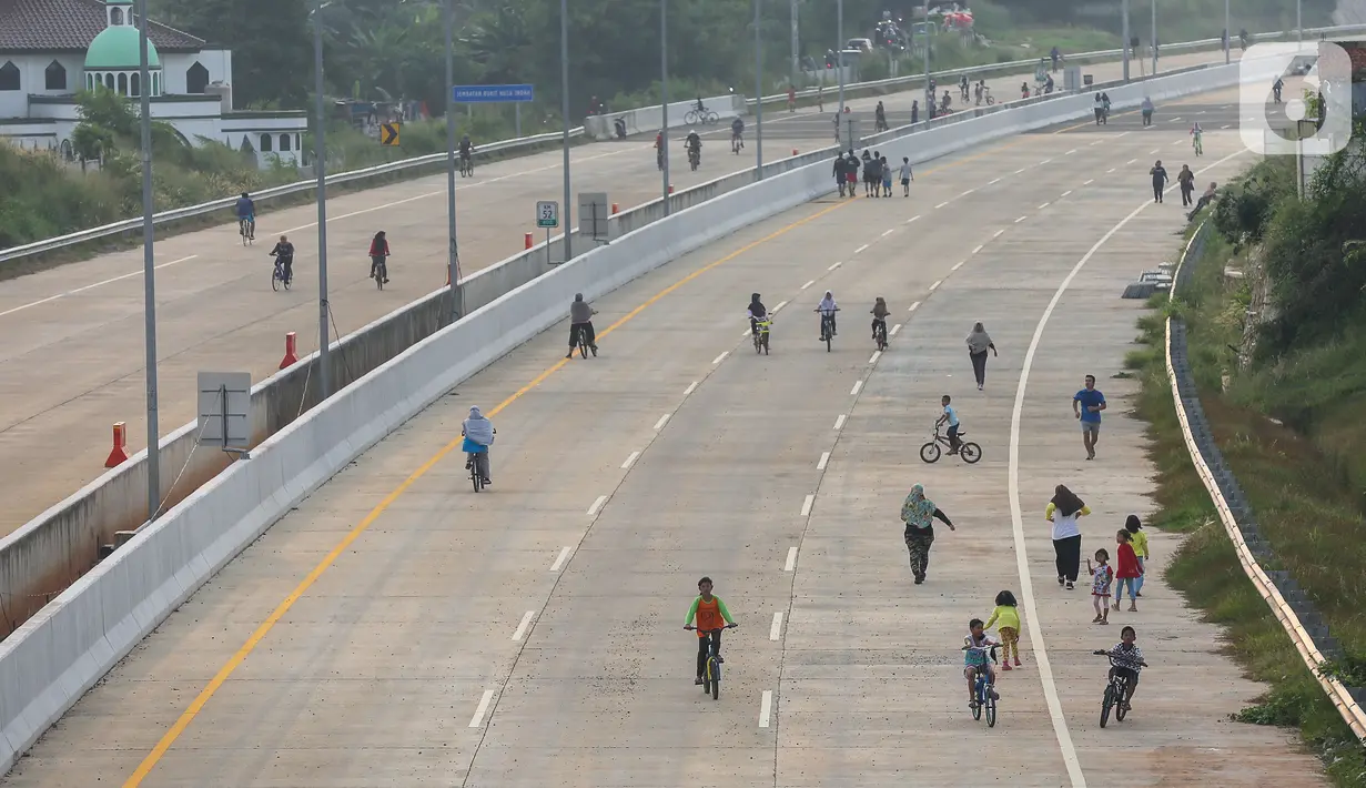 Warga berolahraga sepeda dan berlari pada waktu sore di kawasan pembangunan Tol Serpong Kunciran, Ciputat, Tangerang Selatan, Kamis (25/6/2020). Pembangunan tol yang belum rampung dimanfaatkan sejumlah warga beraktivitas selama pandemi Covid-19. (Liputan6.com/Fery Pradolo)