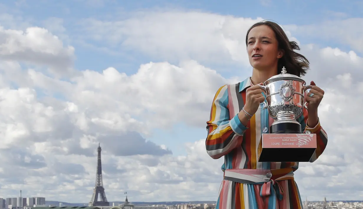 Petenis Polandia Iga Swiatek berpose dengan trofi juara Prancis Terbuka 2020 saat sesi foto di rooftop Galeries Lafayette, Paris, Prancis, Minggu (11/10/2020). Petenis berusia 19 tahun ini mencatatkan diri sebagai sosok Polandia pertama yang memenangkan Grand Slam. (AP Photo/Christophe Ena)