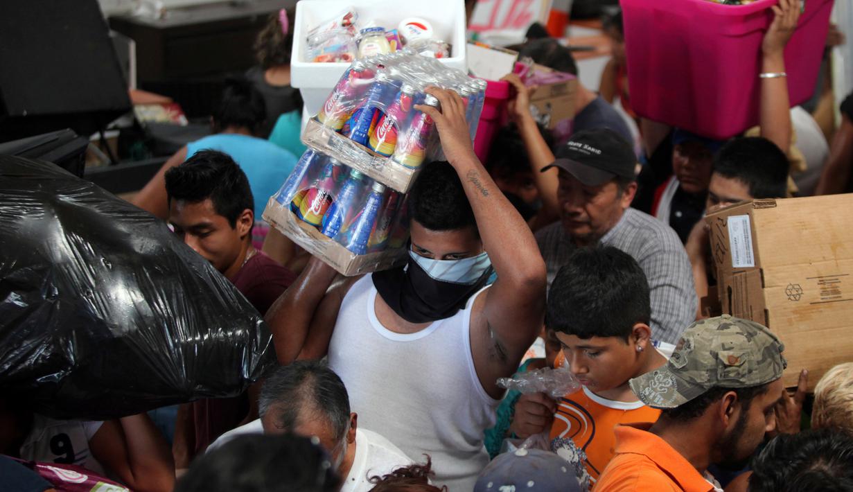 Seorang warga membawa minuman usai menjarah sebuah toko di Veracruz, Meksiko, (5/1). Kepolisian menyebut sebanyak 300 toko digeledah dan lebih dari 600 orang ditangkap. (AP Photo/Felix Marquez)