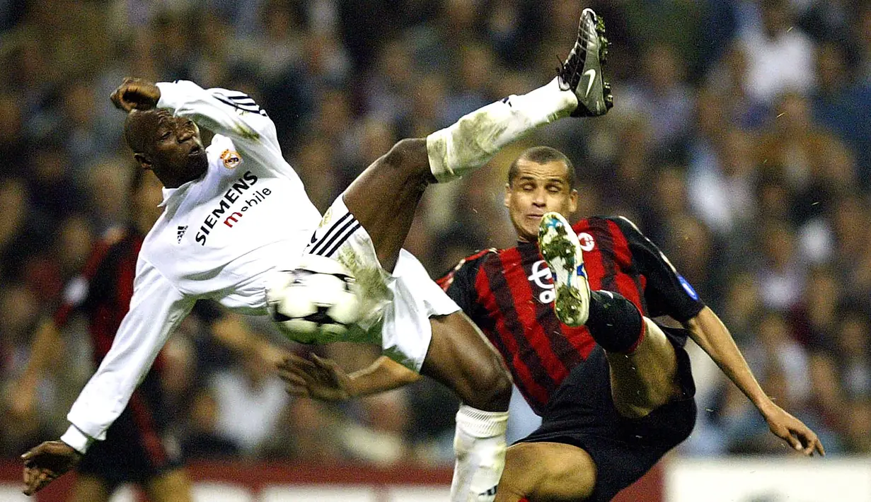 Pemain Real Madrid, Claude Makelele (kiri) berebut bola dengan pemain AC Milan, Rivaldo dalam laga Liga Champions 2002/2003 di Santiago Bernabeu Stadium, Madrid (12/3/2003). Claude Makelele total bermain dalam 96 laga di Liga Champions bersama Nantes, Real Madrid dan Chelsea dengan torehan 1 gol dan 5 assist. (AFP/Christophe Simon)