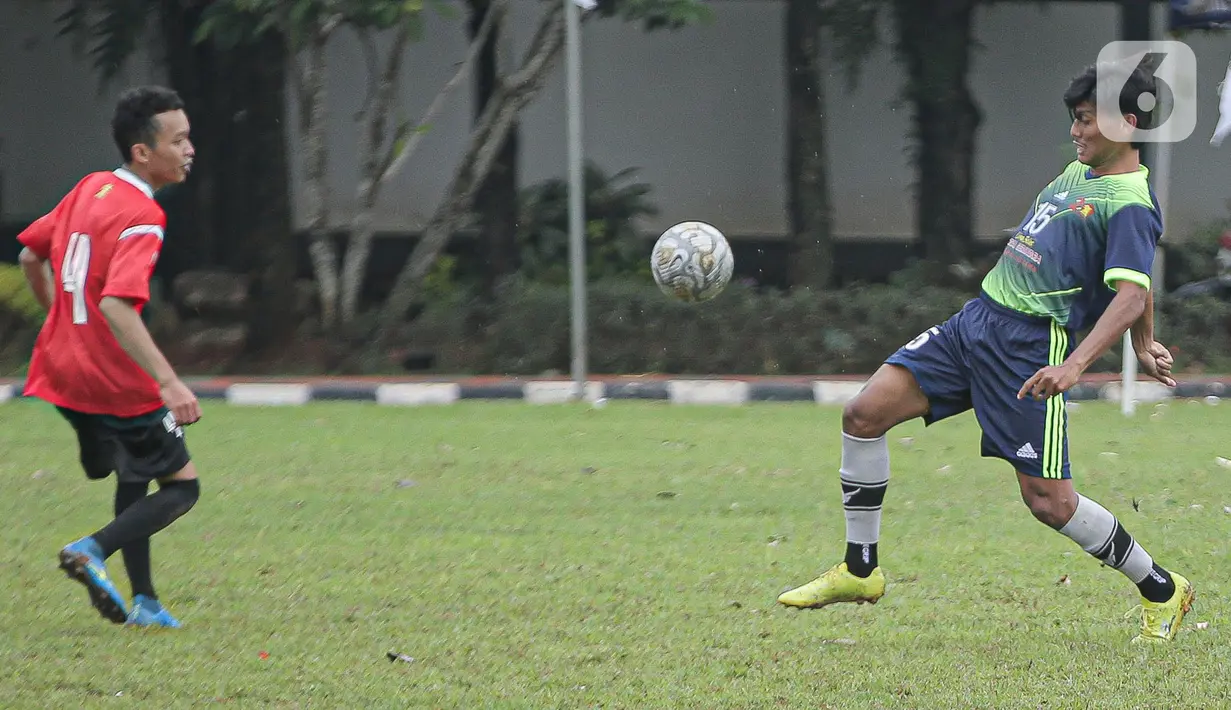 Pemain tim fraksi Gerinda berebut bola dengan pemain tim Gedung Taman DPR saat pertandingan dalam rangkaian HUT Gerindra ke-15 di Lapangan Sepak bola DPR RI, Jakarta, Selasa (31/1/2023). Sejumlah kegiatan dilaksanakan dalam rangkaian HUT Gerinda Ke-15 yang digelar sederhana dan tidak secara foya-foya. (Liputan6.com/Faizal Fanani)