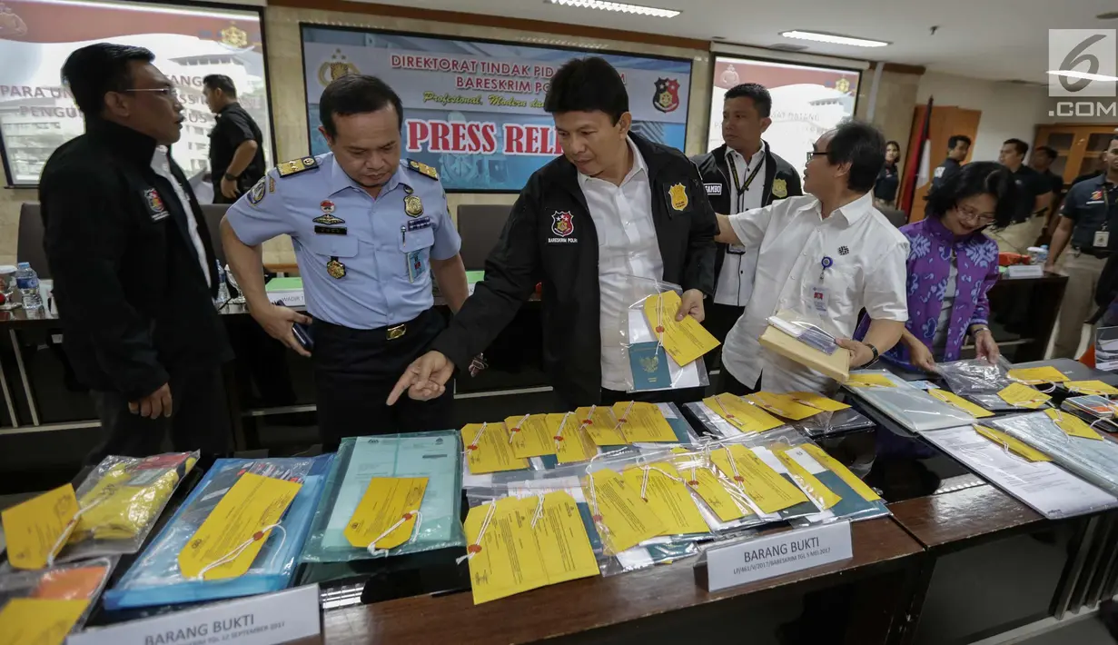 Kabareskrim Mabes Polri, Komjen Pol. Ari Dono Sukmanto (ketiga kiri) memperlihatkan barang bukti paspor saat rilis pengungkapan kasus tindak pidana perdagangan orang, Jakarta, Kamis (21/12). (Liputan6.com/Faizal Fanani)
