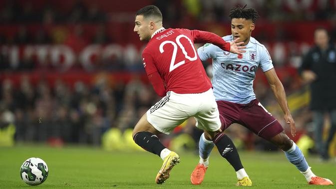 <p>Bek Manchester United, Diogo Dalot mengontrol bola dari kawalan pemain Aston Villa, Tyrone Mings pada pertandingan putaran ketiga Piala Liga Inggris 2022 di Stadion Old Traffodr, Manchester, Inggris, Jumat (11/11/2022). MU menang atas Aston Villa dengan skor 4-2. (AP Photo/Dave Thompson)</p>