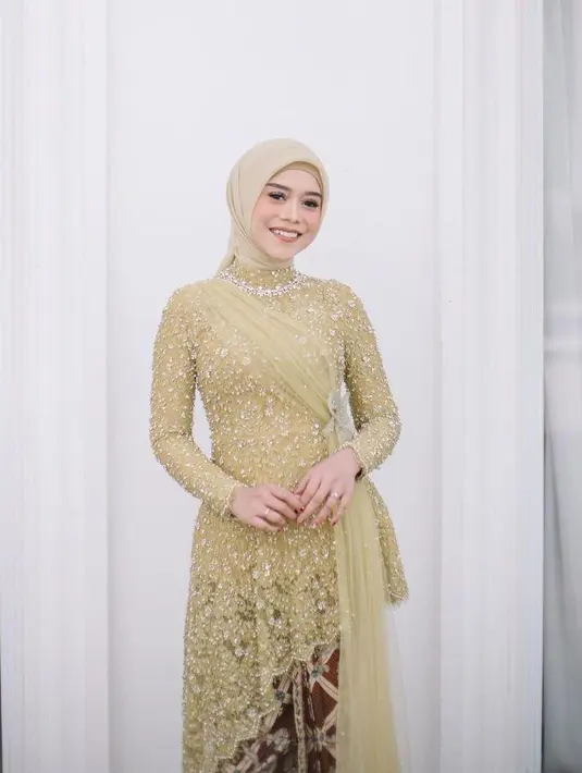 Lesti tampak begitu anggun saat mengenakan kebaya modern berwarna hijau dengan detail full payet. Kebaya tersebut juga dilengkapi dengan  kain tile yang dibentuk layaknya selendang. [Instagram/renzilazuardi]
