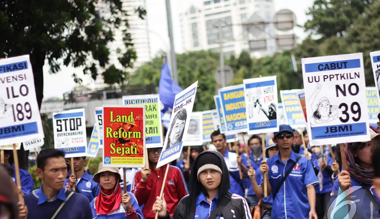 Para buruh membawa beragam tulisan saat menggelar aksi di Istana Negara, Jakarta, Kamis (18/12/2014). (Liputan6.com/Faizal Fanani)