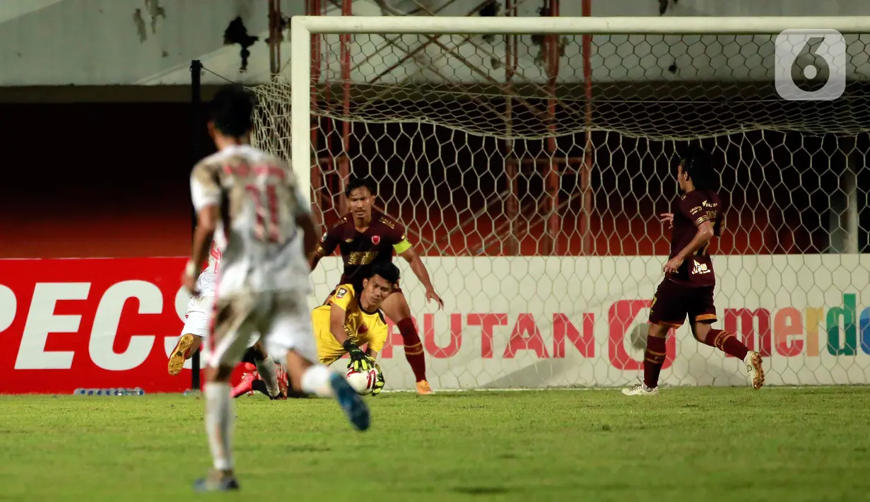 Kiper PSM Makassar, Hilman Syah (kanan) berhasil menangkap bola hasil tendangan pemain Persija Jakarta dalam pertandingan semifinal leg pertama Piala Menpora 2021 di Stadion Maguwoharjo, Sleman, Kamis (15/4/2021). PSM Makassar vs Persija Jakarta bermain imbang 0-0. (Bola.com/Ikhwan Yanuar)