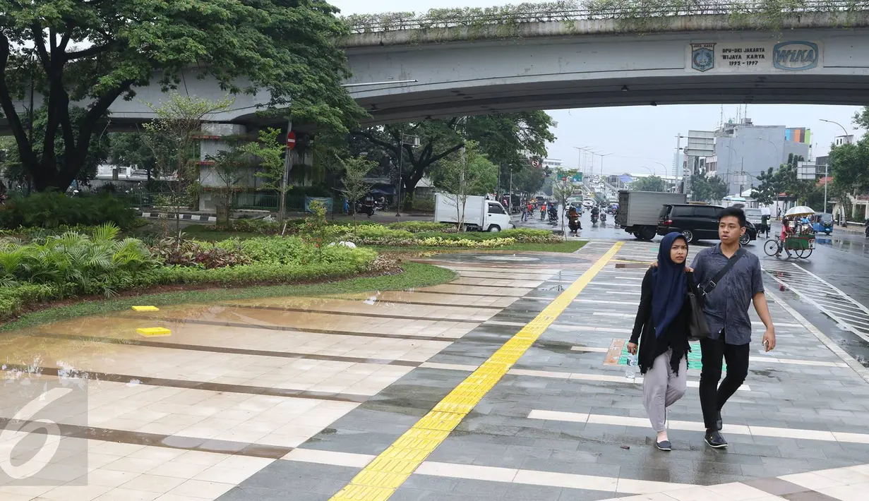 Pejalan kaki melintasi trotoar di Jalan Jatibaru Raya, Tanah Abang, Jakarta, Senin (21/11). Meskipun belum sepenuhnya selesai, namun trotoar yang dulu dipenuhi PKL tersebut kini telah berubah menjadi bersih dan asri. (Liputan6.com/Immanuel Antonius)