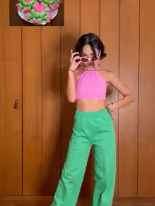 Mengenakan atasan crop top berwarna pink dipadu celana panjang hijau, pelantun "Sahabat Setia" ini mengaku sebagai cewek kue carabikang. (Foto: Instagram/@andienaisyah)