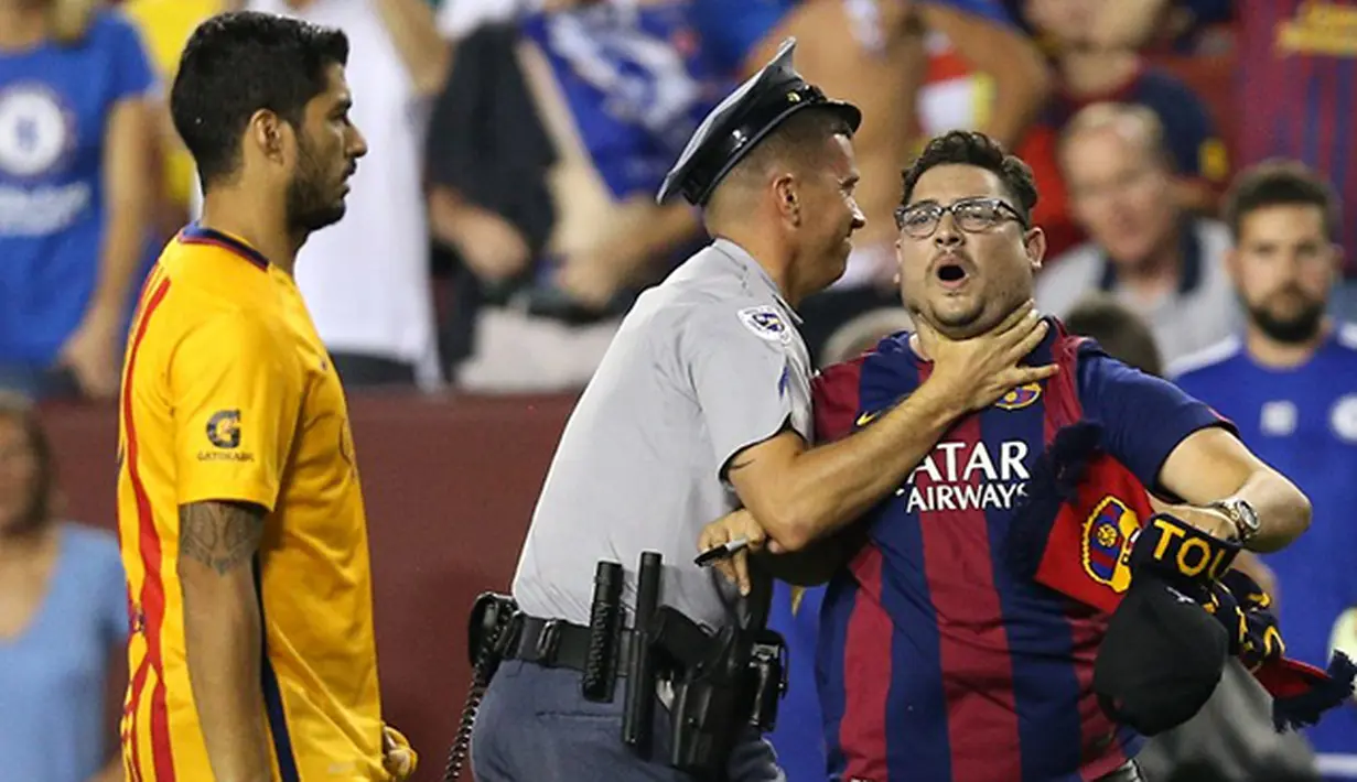 Pihak Kepolisian mengamankan seorang suporter yang berusaha mendekati pemain Barcelona Luis Suarez usai bertanding melawan Chelsea pada Laga International Champions Cup di FedEx Field, AS, Rabu (29/7/2015) pagi WIB. (AFP/Getty Images/ Patrick Smith)