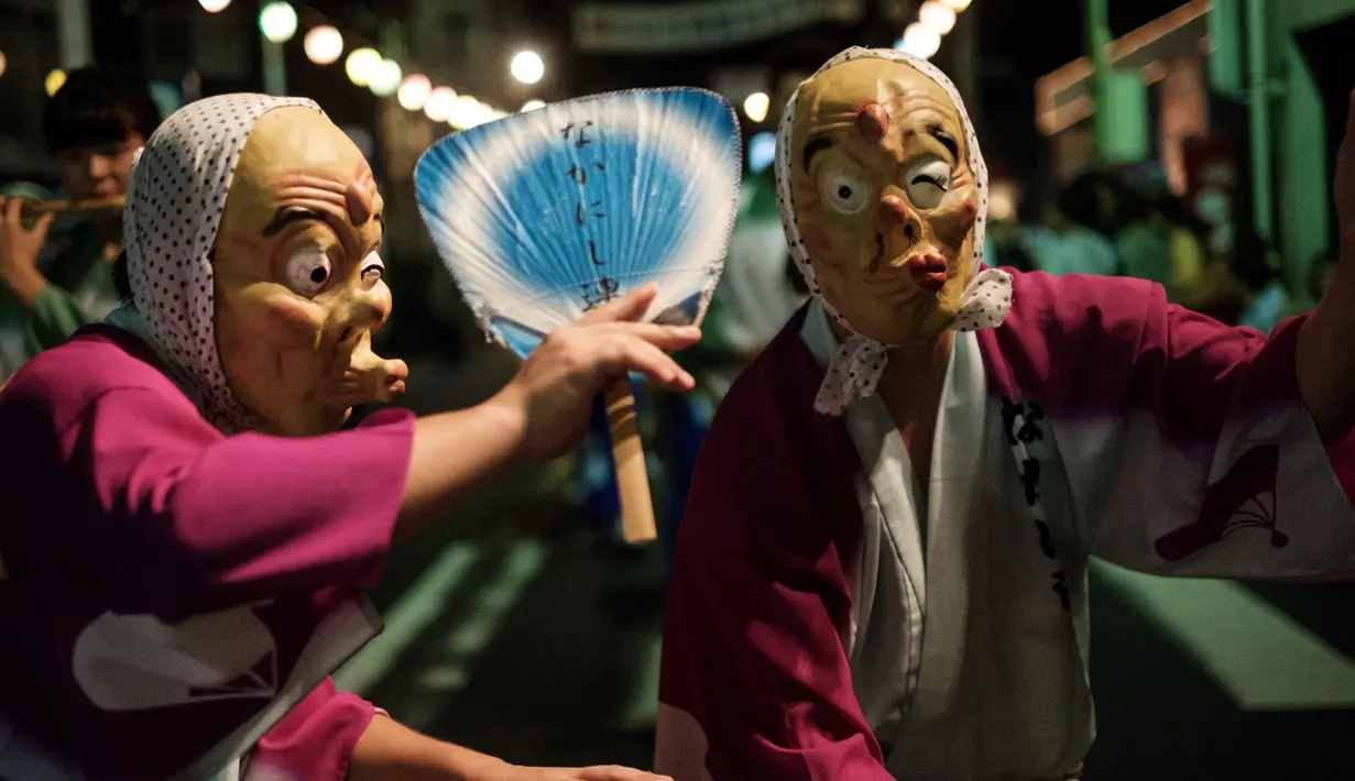 Peserta mengenakan kostum hantu menari saat festival Awa Odori di Kota Miyoshi, Jepang (16/8). Warga setempat percaya, acara ini juga untuk menyambut jiwa leluhur mereka yang kembali ke dunia untuk mengunjungi keluarganya. (AFP Photo/Yasuyoshi Chiba)