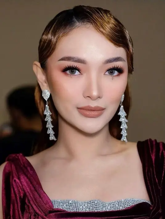 Penampilannya diperlengkap dengan pulasan makeup nuansa merah pada eyeshadow dan blush on oleh MUA Cantika Wanna Dewi. Sementara untuk lipstick, perempuan 31 tahun ini memilih warna yang lebih nude (Instagram/cantikawannadewi).