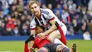 Penyerang Manchester United, Anthony Martial, terjatuh berebut bola dengan bek sayap West Bromwich Albion, Craig Dawson. Hasil ini merupakan kekalahan ke-8 MU pada musim ini pada ajang Liga Premier Inggris. (Reuters/Darren Staples)