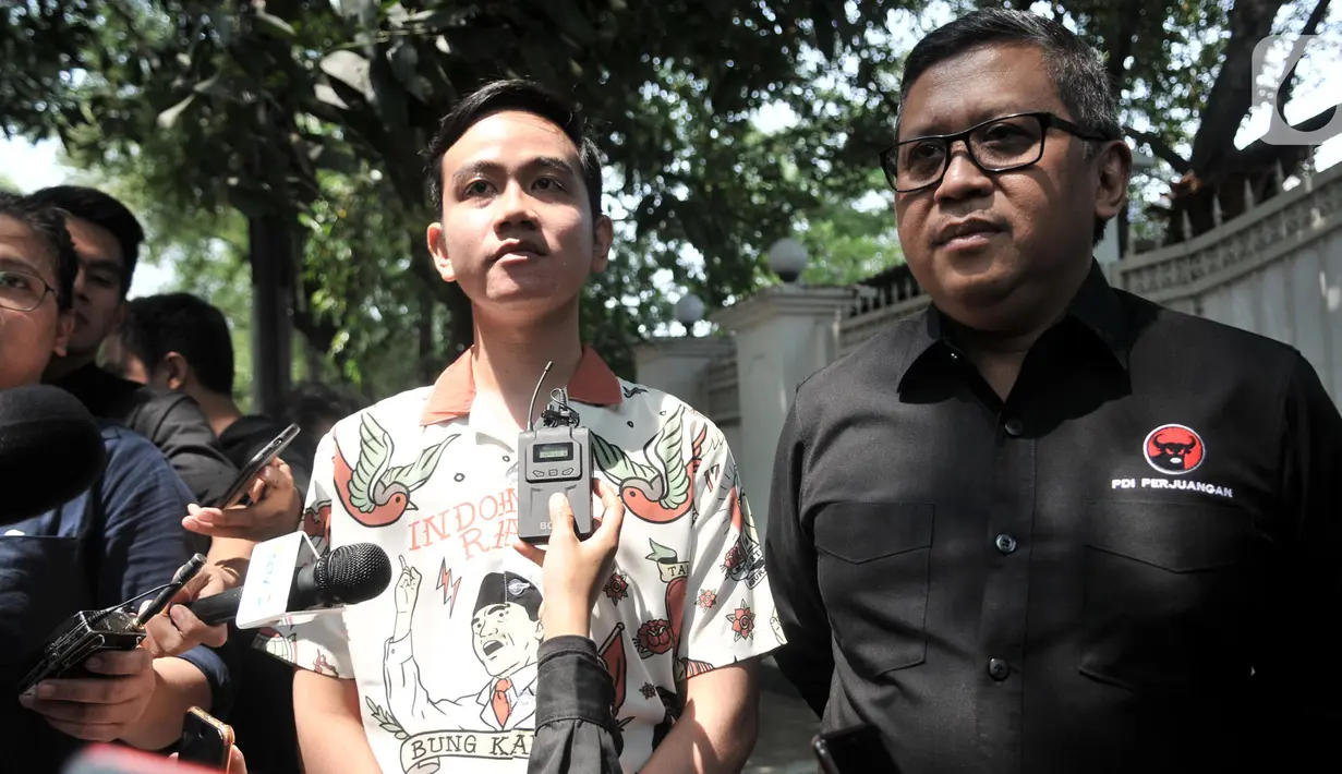 Putra Presiden Joko Widodo, Gibran Rakabuming Raka didampingi Sekjen PDI Perjuangan Hasto Kristiyanto memberikan keterangan kepadaa awak media usai melakukan pertemuan dengan Ketum PDIP Megawati Soekarnoputri di Jalan Teuku Umar, Jakarta, Kamis (24/10/2019). (merdeka.com/Iqbal Nugroho)