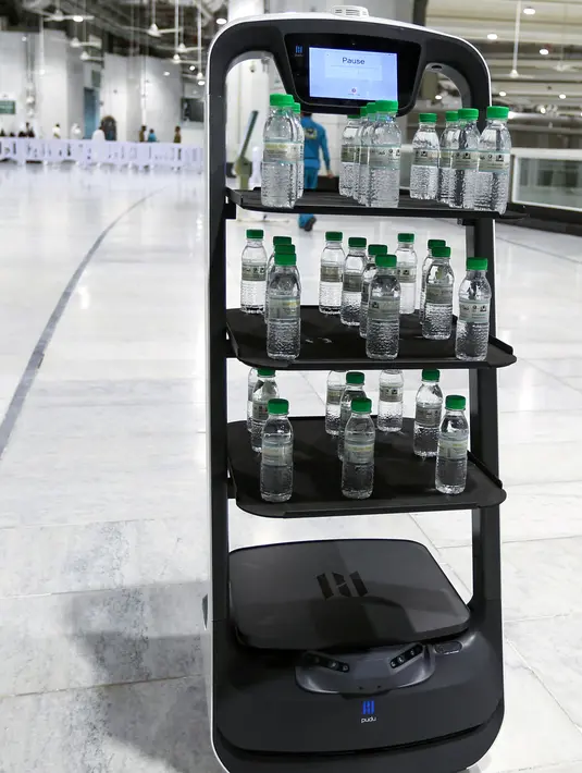 Gambar pada 15 Juni 2021, menunjukkan robot pembawa air Zamzam di sekitar Masjidil Haram di Makkah, Arab Saudi. Ini dilakukan agar para jemaah haji tak berdesakan saat akan minum air suci zamzam dan mengurangi kontak langsung dengan staf sebagai langkah mencegah penyebaran Covid-19. (AFP Photo)