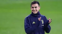 Striker Juventus, Paulo Dybala tersenyum sambil bertepuk tangan selama latihan tim di Contassina, Turin, Italia (6/11). Di pertemuan pertama Juventus menang tipis atas Manchester United 1-0 berkat Gol striker Paulo Dybala. (AFP Photo/Isabella Bonotto)