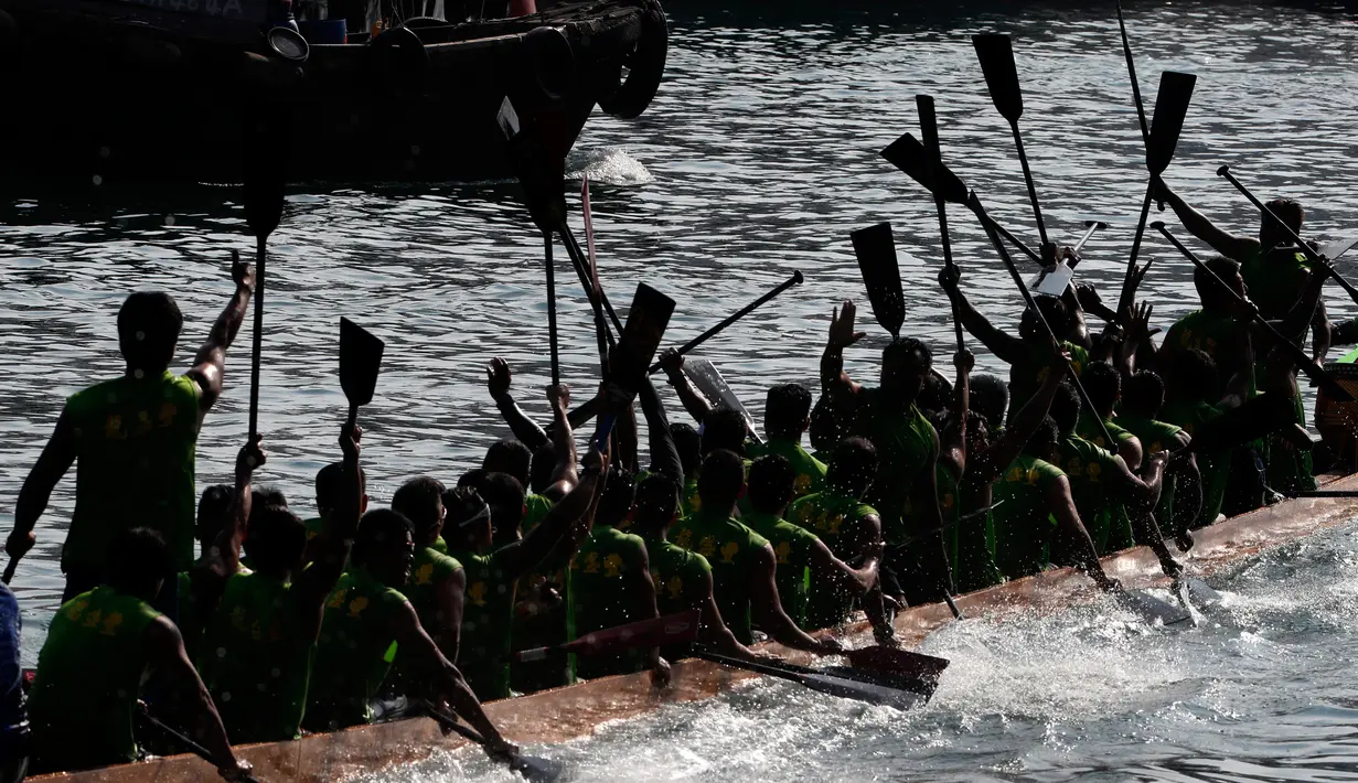 Peserta melakukan selebrasi setelah memenangkan perlombaan perahu naga di Hong Kong, Selasa, (30/5). Festival Perahu Naga jatuh pada hari kelima bulan kelima kalender Cina. (AP Photo / Vincent Yu)