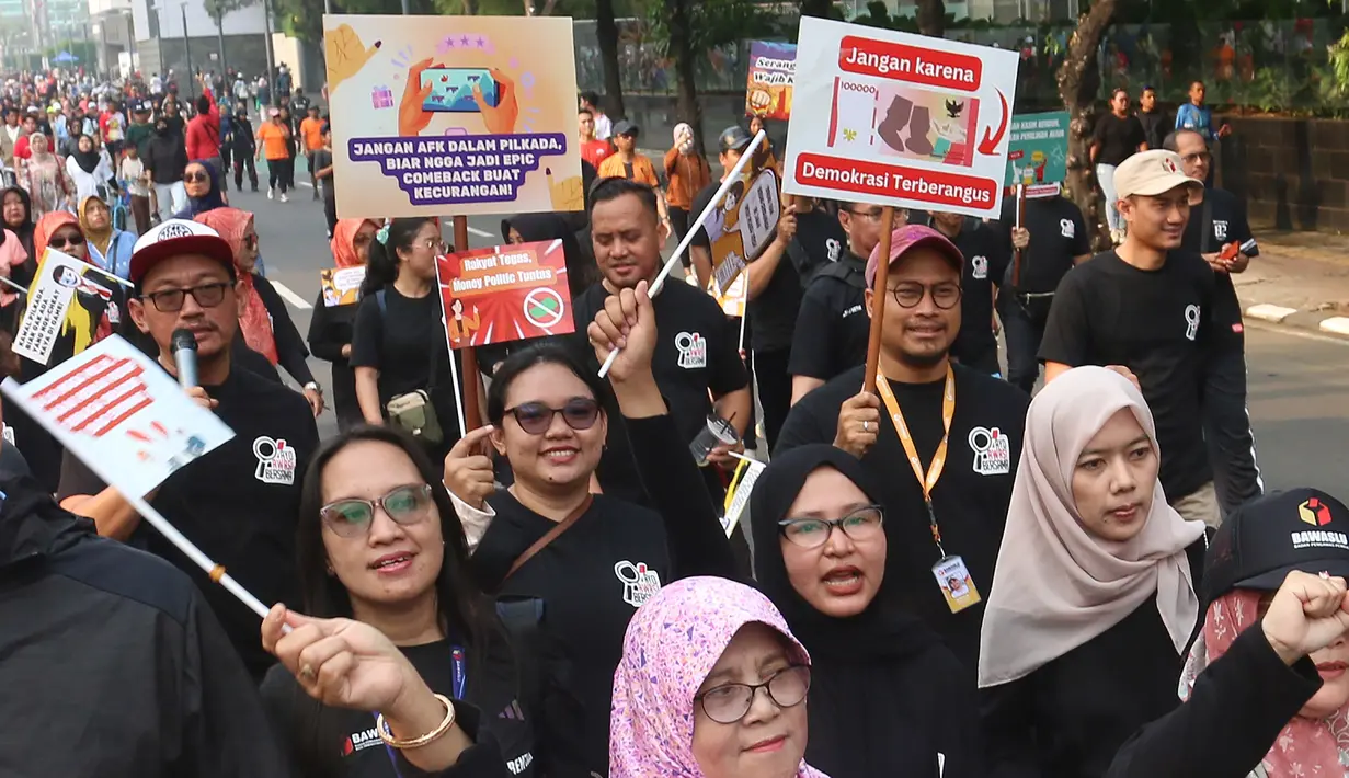 Peserta mengikuti pawai sosialisasi pengawasan Pilkada Serentak 2024 saat Hari Bebas Kendaraan Bermotor, Jalan MH Thamrin, Jakarta, Minggu (22/9/2024). (merdeka.com/Arie Basuki)