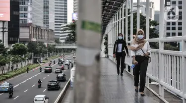 Pekerja melintasi jembatan penyeberangan orang saat jam pulang kantor di kawasan Sudirman, Jakarta, Senin (14/9/2020). Pengurangan aktivitas pekerja di perkantoran menjadi fokus utama Pemprov DKI Jakarta dalam penerapan PSBB pada 14-27 September 2020. (merdeka.com/Iqbal S. Nugroho)