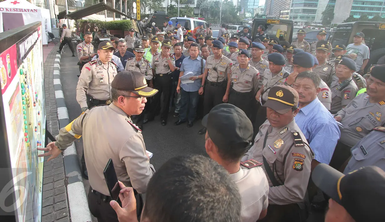 Polisi tengah melakukan apel pengamanan di Kawasan Bundaran HI, Jakarta, kamis (31/12). Polisi menerjukan 8.978 personil untuk menjaga malam pergantian tahun di Jakarta. (Liputan6.com/Angga Yuniar)