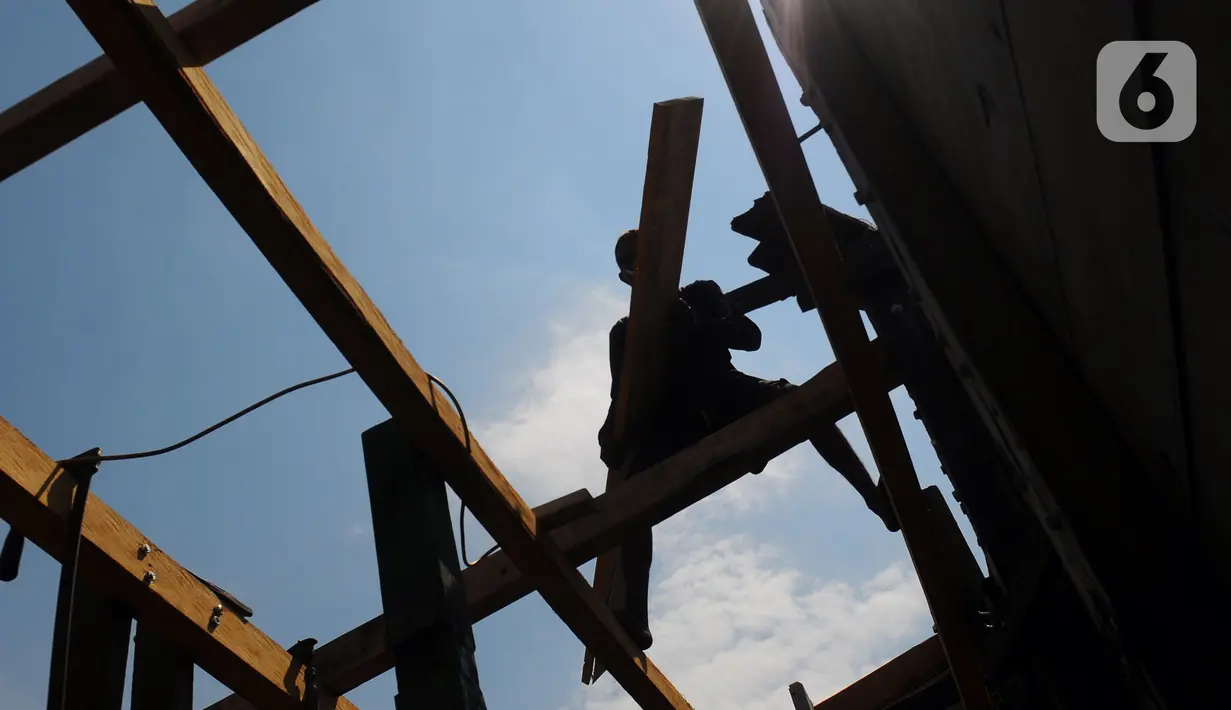 Tukang kayu memperbaiki kapal motor di Pelabuhan Kalibaru, Jakarta, Rabu (8/3/2023). Tukang kayu mengalami kesulitan bahan baku yang mulai jarang. (merdeka.com/Imam Buhori)