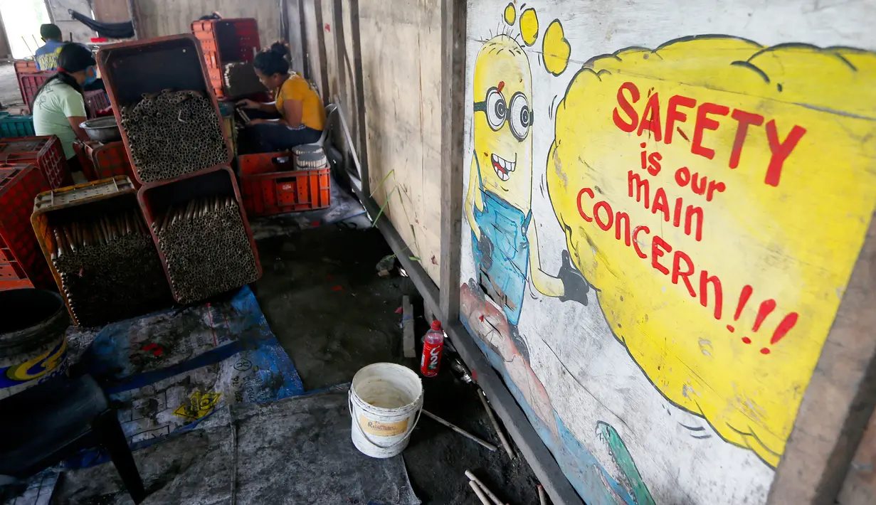 Aktivitas pekerja membuat kembang api di dalam sebuah gubuk di provinsi Bulacan, utara Manila, Rabu (27/12). Seperti banyak negara di Asia, warga Filipina juga akan merayakan malam pergantian tahun dengan kembang api tradisional. (AP/Bullit Marquez)