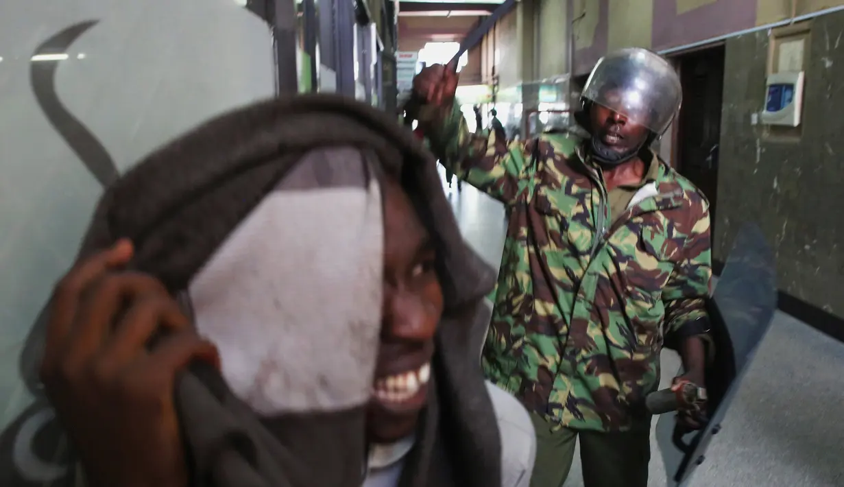 Para Polisi memukuli seorang demonstran di dalam sebuah gedung saat bentrokan di Nairobi, Kenya (16/5). Demonstran menuntut pembubaran otoritas pemilu karena adanya dugaan korupsi. (REUTERS/Goran (REUTERS/Goran Tomasevic)