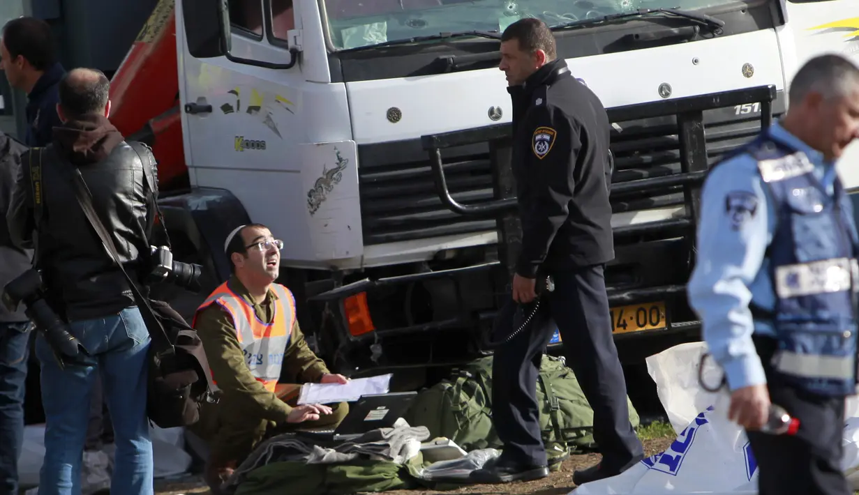 Petugas kepolisian melakukan penyelidikan di lokasi serangan truk yang menabrak sejumlah tentara Israel di sebuah tempat wisata di Yerusalem, Minggu (8/1). Supir truk tersebut langsung ditembak mati paska melakukan aksinya. (AP Photo/Mahmoud Illean)