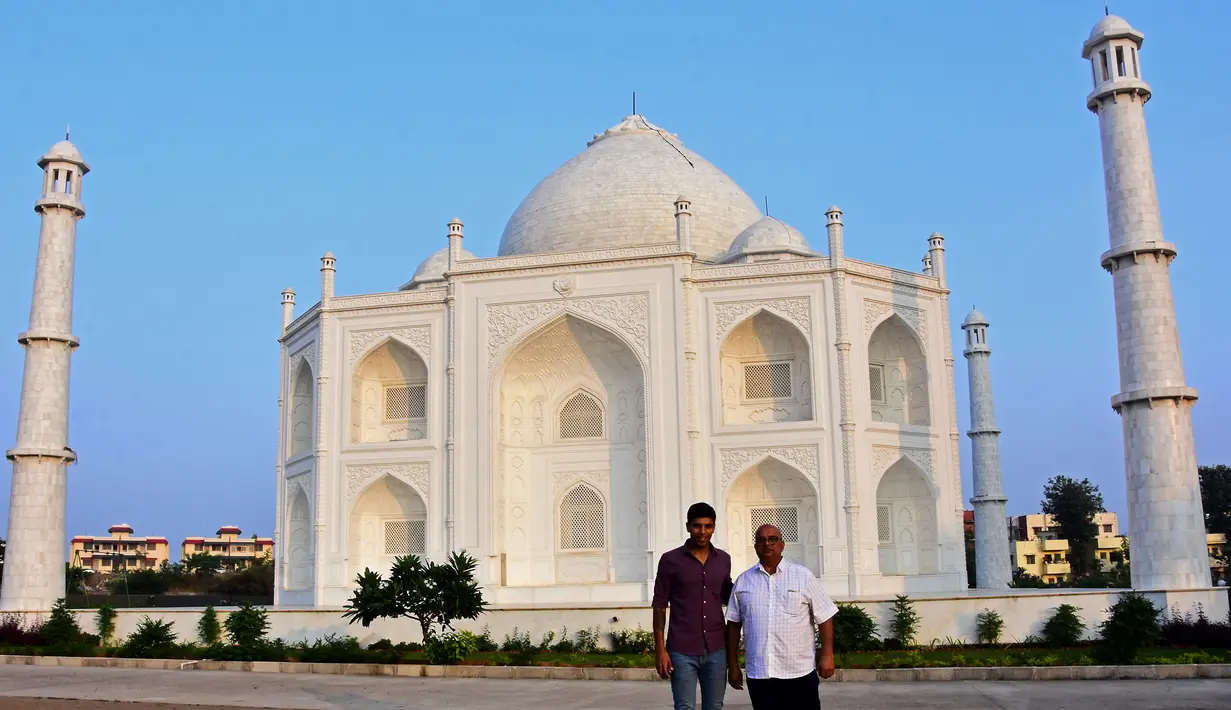 Pengusaha India Anand Prakash Chouksey (kanan) dan putranya Kabir berpose di depan replika Taj Mahal di Burhanpur, negara bagian Madhya Pradesh, India pada 25 November 2021. Chouksey menghabiskan waktu hingga tiga tahun membangun replika Taj Mahal untuk istrinya tersebut. (Uma Shankar MISHRA / AFP)