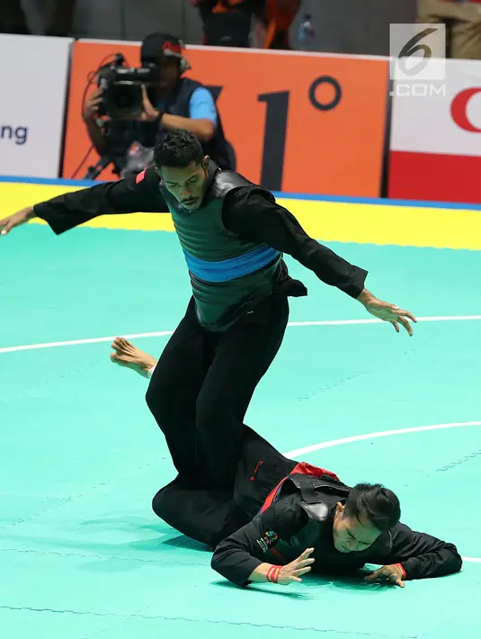 Pesilat Timor Leste, David No-Ano Ximenes (atas) bertanding melawan pesilat Indonesia, Komang Harik Adiputra dalam kelas 65-70 kg Putra Asian Games 2018 di Padepokan Pencak Silat TMII, Jakarta, Kamis (23/8). Komang unggul 5-0. (Liputan6.com/Fery Pradolo)