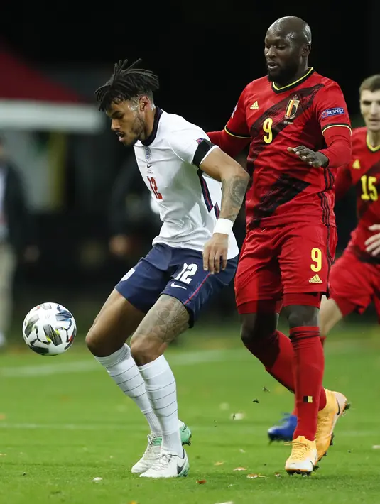 Penyerang Belgia, Romelu Lukaku berusaha merebut bola bek Inggris, Tyrone Mings pada pertandingan UEFA Nations League di stadion King Power di Leuven, Belgia, Minggu (15/11/2020). Belgia menang atas Inggris 2-0. (AP Photo/Francisco Seco)