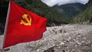 Bendera Partai Komunis berkibar saat polisi paramiliter melakukan operasi pencarian dan penyelamatan di dekat Pelabuhan Gyirong yang rusak akibat tanah longsor dua hari sebelumnya di Kabupaten Gyirong, wilayah Tibet di Tiongkok bagian barat, Sabtu, 29 Agustus 2026. (AFP/ CNS)