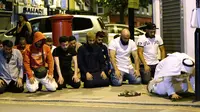 Umat muslim melaksanakan salat di lokasi sebuah van yang menabrak pejalan kaki di Finsbury Park Road, London utara, Senin (19/6). Mereka menggelar salat di pinggir jalan untuk mendoakan para korban insiden penabrakan. (Yui Mok/PA via AP)