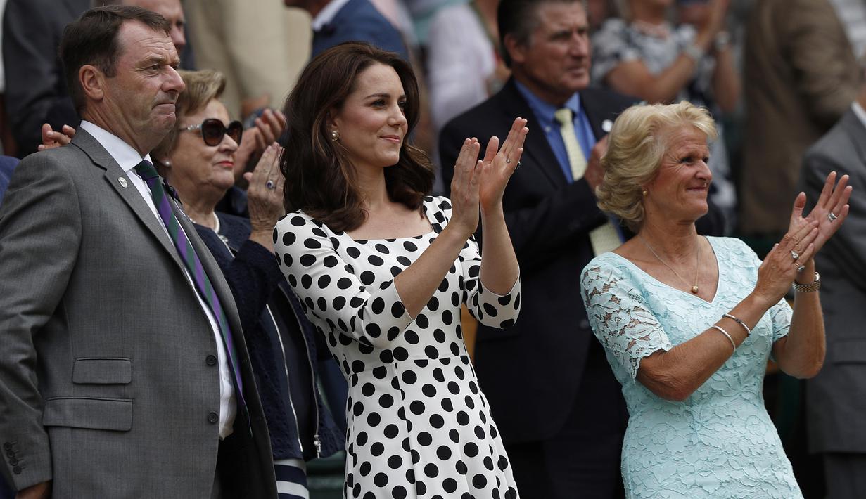 Kate Middleton (tengah) bertepuk tangan setelah petenis asal Inggris, Andy Murray berhasil mengalahkan petenis Rusia, Alexander Bublik pada pertandingan babak pertama Wimbledon di London, Inggris, (3/7). (AFP Photo/Adrian Dennis)
