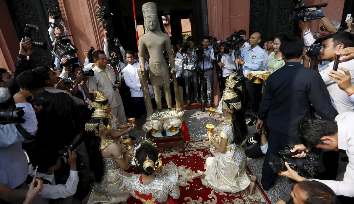 Upacara penyambungan kepala patung dewa Hindu dari abad ke-7 ke tubuhnya di Museum Nasional Kamboja, di Phnom Penh, Kamis (21/1). Prancis mengembalikan kepala patung dewa Harihara setelah diambil lebih dari 130 tahun yang lalu. (REUTERS/Samrang Pring)