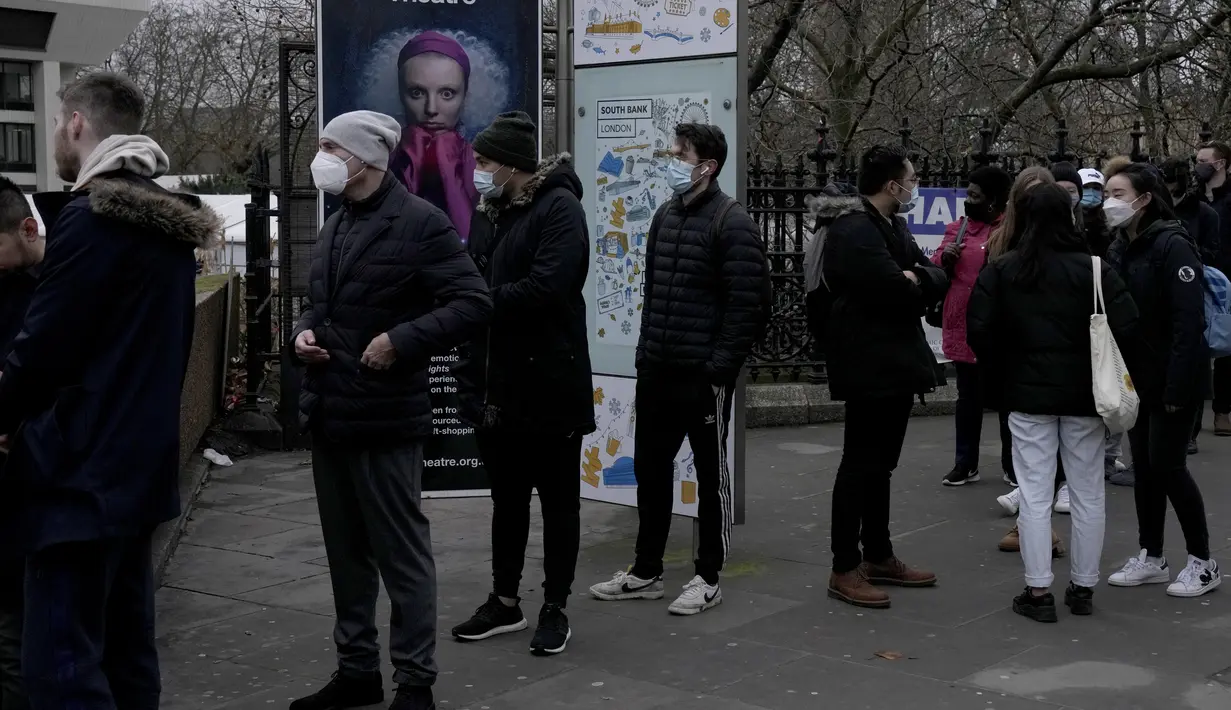 Orang-orang antre untuk mendapatkan suntikan vaksin booster Covid-19 di Rumah Sakit St Thomas, London, Senin (13/12/2021). Perdana Menteri Inggris Boris Johnson pada Minggu (12/12) memperingatkan "gelombang pasang" yang meningkat akibat Varian Omicron. (AP Photo/Matt Dunham)