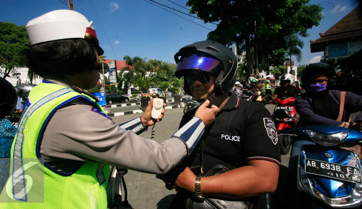 Seorang Polwan mengancingkan tali helm pada operasi lalu lintas di Abu Bakar Ali,Yogyakarta, (19/5). Operasi ini untuk menekan angka kecelakaan, petugas memberikan surat tilang di tempat kepada pelanggar lalu lintas. (Liputan6.com/Boy Harjanto)