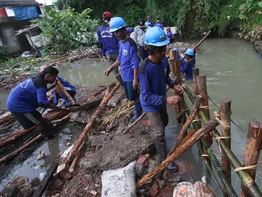 Pekerja menyelesaikan pembuatan tanggul darurat di kawasan Jatipadang, Jakarta, Rabu (22/11). Jebolnya tanggul Kali Pulo di kawasan tersebut menyebabkan puluhan rumah terendam banjir. (Liputan6.com/Immanuel Antonius)