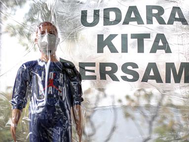 Boneka dalam plastik dibawa saat aktivis lingkungan melakukan demonstrasi di depan Balai Kota DKI Jakarta, Jumat (16/9/2022). Aksi tersebut memperingati satu tahun kemenangan warga negara untuk hak udara bersih. Meski telah menang, menurut mereka belum ada satu pun putusan hakim yang dijalankan para tergugat. (Liputan6.com/Faizal Fanani)