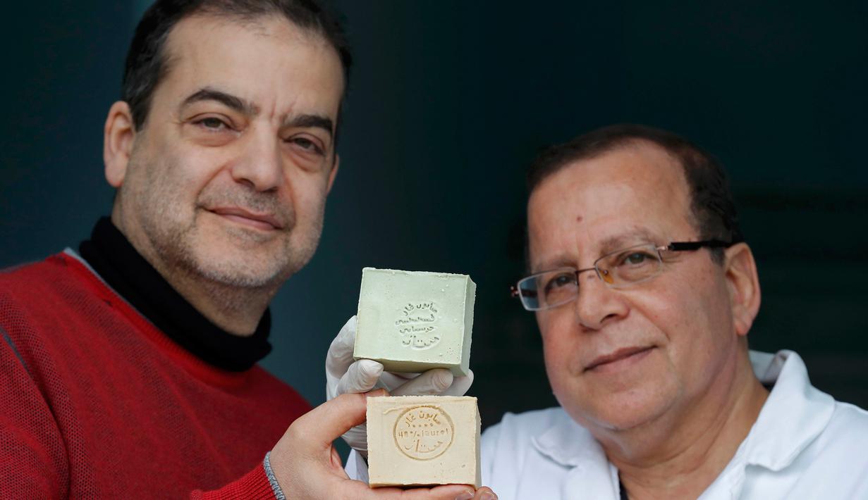Samir Constantini bersama rekannya menunjukkan sabun khas Aleppo, Santeny, Paris, Kamis (22/12). Kota Aleppo yang sedang perang membuat dirinya memindahkan produksi sabun ke Perancis. (REUTERS / Christian Hartmann)