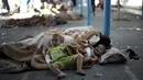 Dua orang bocah harus mengungsi dan tidur di tempat yang tak layak. Mereka kehilangan tempat tinggal yang hancur akibat  serangan udara Israel(15/07/2014) (AFP PHOTO/MAHMUD HAMS)