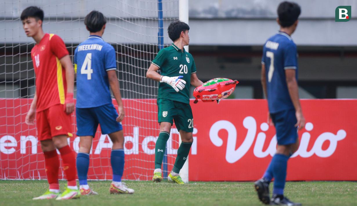 Kiper Timnas Thailand U-19, Chommaphat Boonloet menyingkirkan balon berbentuk jerapah yang memasuki lapangan pada laga perebutan juara ketiga Piala AFF U-19 2022 antara Timnas Vietnam U-19 melawan Timnas Thailand U-19 di Stadion Patriot Candrabhaga, Bekasi (15/07/2022). (Bola.com/Bagaskara Lazuardi)