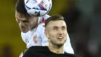 Bek Denmark, Jannik Vestergaard berebut bola dengan pemain Austria, Sasa Kalajdzic pada pertandingan UEFA Nations League di Stadion Ernst Happel di Wina, Austria, Selasa (7/6/2022). Denmark menang tipis atas Austria 2-1. (AP Photo/Andreas Schaad)